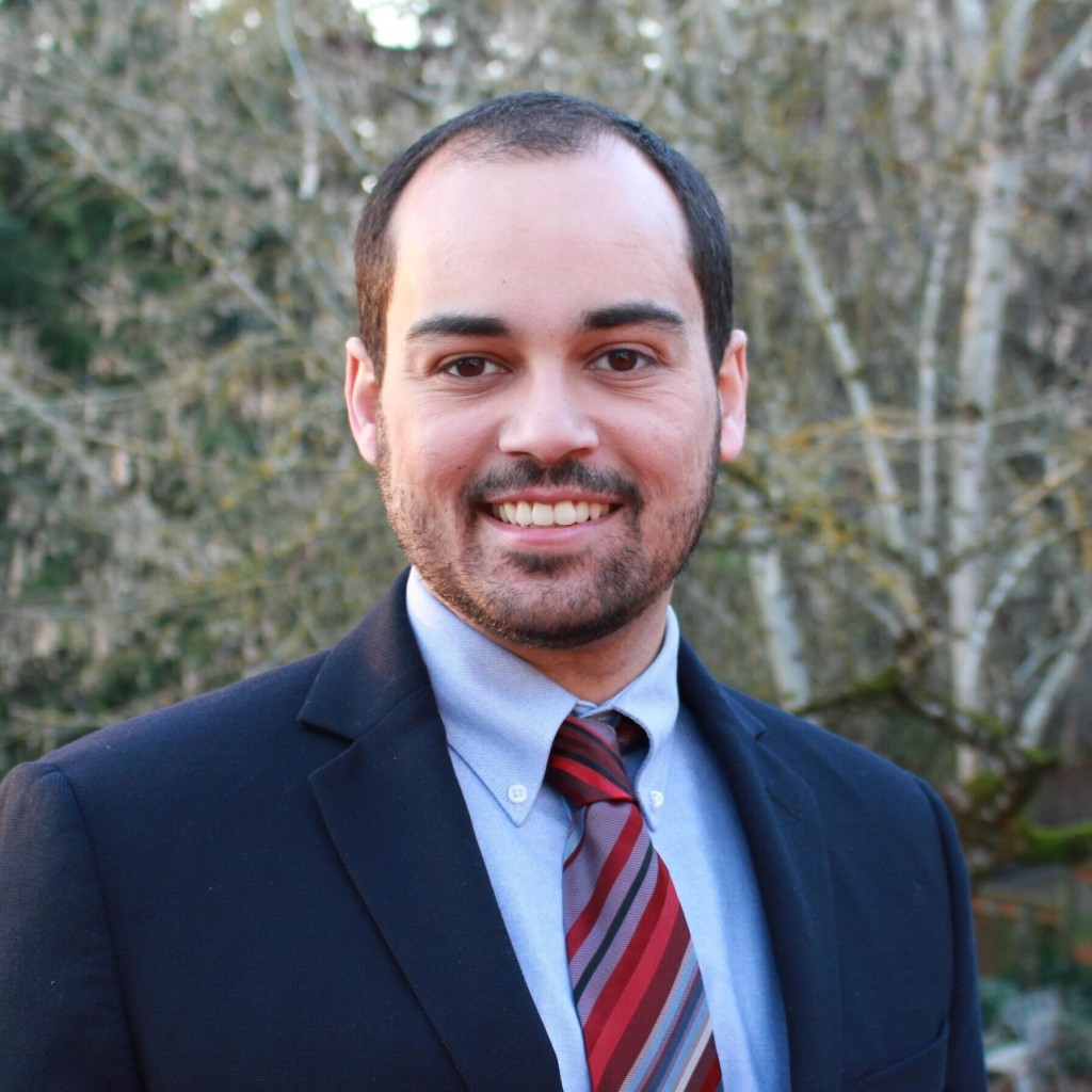 A man in a suit and tie smiling for the camera.