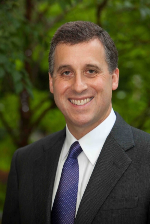 A man in suit and tie smiling for the camera.